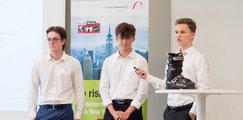 Die drei Teammitglieder präsentieren ihre Produktidee vorne auf der Bühne