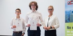 Siegerteam Platz 2 "CoreCraft" hält Siegerurkunde hoch, daneben steht Sandra Stenger vom bbw e.V.