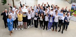Großes Gruppenfoto der Abschlussveranstaltung mit allen jubelnden Finalteams, Jurymitglieder und Förderer